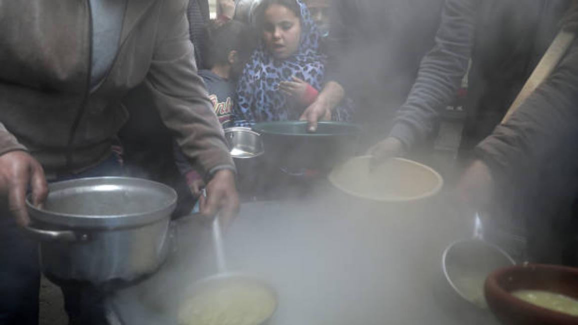 	Palestinians gather to get soup offered for free during the Muslim fasting month of Ramadan, in Gaza City on April 13, 2021. (Photo by Majdi Fathi/NurPhoto via Getty Images)