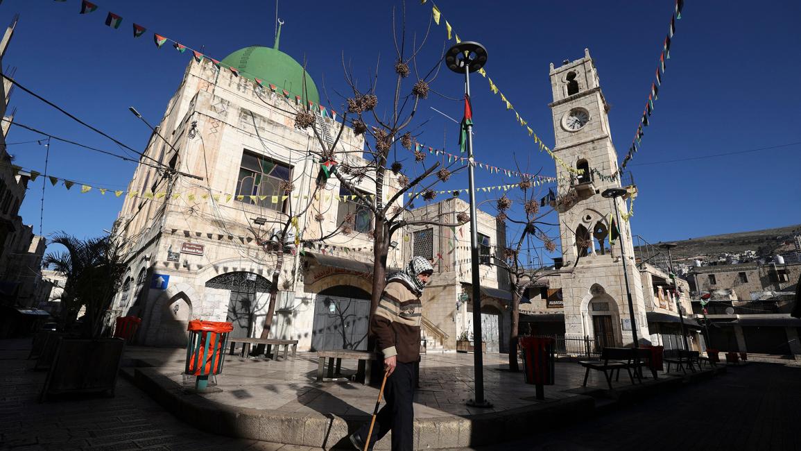 فلسطيني يسير أمام ساحة فارغة (جعفر اشتية/Getty)