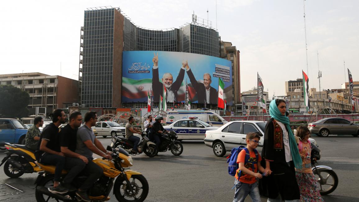 صورة مرفوعة في أحد شوارع طهران تجمع هنيّة وبزشكيان التقطت خلال مراسم تنصيب الرئيس الإيراني (5/8/2024 الأناضول) 