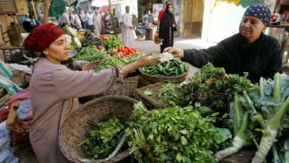 بائعة خضروات في سوق إمبابة الشعبي بمحافظة الجيزة (خالد دسوقي/ فرانس برس)